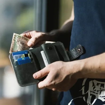 a man taking a note out of his wallet